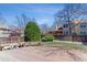 Inviting backyard with a deck, lawn, mature trees, and privacy fence at 1550 S Syracuse St, Denver, CO 80231