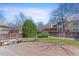 Private backyard featuring a wooden deck, green lawn, mature landscaping, and a wooden fence at 1550 S Syracuse St, Denver, CO 80231