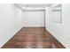 Finished basement with wood floors, white walls, and access to storage areas at 1550 S Syracuse St, Denver, CO 80231