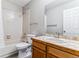 Cozy bathroom featuring a tub/shower combo and a wood vanity with a tiled countertop at 1550 S Syracuse St, Denver, CO 80231
