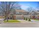 Inviting townhome with a well-manicured lawn, two-car garage, and brick accents on a tree lined street at 1550 S Syracuse St, Denver, CO 80231