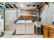 Unfinished laundry room in the basement with a washer, dryer, and utility sink at 1550 S Syracuse St, Denver, CO 80231