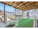 Enclosed back porch with artificial grass and views of the backyard and surrounding homes at 195 Briggs St, Erie, CO 80516