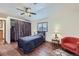 Bedroom with a ceiling fan, wood floors, a window with blinds, and a comfy bed and accent chair at 195 Briggs St, Erie, CO 80516