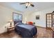 Bedroom with a ceiling fan, wood floors, a window with blinds, and a comfy bed and accent chair at 195 Briggs St, Erie, CO 80516