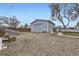 Detached two-car garage with a graveled backyard area, a fence, and a greenhouse at 195 Briggs St, Erie, CO 80516