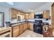 Galley-style kitchen featuring oak cabinets, a black gas range, and tile flooring at 195 Briggs St, Erie, CO 80516