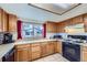 Well-lit kitchen with wood cabinets, tile flooring, and essential appliances at 195 Briggs St, Erie, CO 80516