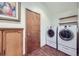 This laundry room features modern appliances, storage cabinets and wood-look floors at 195 Briggs St, Erie, CO 80516