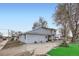 Back exterior of the home featuring mature trees, gravel landscaping, and vinyl siding at 195 Briggs St, Erie, CO 80516