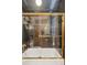 Bathtub with a glass shower door and gold trim, along with tiled walls in the bathroom at 471 S Grant St, Denver, CO 80209