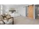 Bedroom with carpet, a barn door to bathroom, and two upholstered chairs at 7068 E Briarwood Dr, Centennial, CO 80112