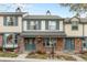 Charming townhome featuring a brick facade, neutral siding, blue shutters, and covered entryway, enhancing its curb appeal at 7068 E Briarwood Dr, Centennial, CO 80112