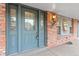 Inviting townhome with a brick exterior and a charming blue front door with glass panels and decorative sidelights at 7068 E Briarwood Dr, Centennial, CO 80112