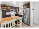 Kitchen with dark cabinets, stainless steel refrigerator, and a wooden table with chairs at 7068 E Briarwood Dr, Centennial, CO 80112