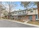 Beautiful townhomes showcasing neutral siding, brick accents, blue shutters, and well-maintained landscaping for added charm at 7068 E Briarwood Dr, Centennial, CO 80112
