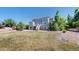 Expansive backyard features a multi-level deck, grass, and mature trees at 9353 E 146Th Ave, Brighton, CO 80602