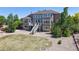 Manicured backyard featuring a multi-level deck, trees, and stone at 9353 E 146Th Ave, Brighton, CO 80602