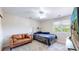 Bedroom features a ceiling fan, large windows, a bed, and a sofa at 9353 E 146Th Ave, Brighton, CO 80602