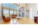 Bright living room with a soaring ceiling, large windows, fireplace, and hardwood flooring at 9353 E 146Th Ave, Brighton, CO 80602