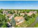 Aerial view of a home and neighborhood with mature trees, a stream, and a bridge under a sunny blue sky at 10478 W 82Nd Ave, Arvada, CO 80005