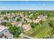 An aerial view of a residential neighborhood with lush greenery, a river, and a walking bridge on a sunny day at 10478 W 82Nd Ave, Arvada, CO 80005