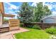 Spacious backyard with lush lawn, mature trees, a deck, and a patio ideal for outdoor gatherings at 10478 W 82Nd Ave, Arvada, CO 80005
