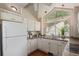 Well-lit kitchen with ample countertop space, bright white cabinets, and a large window at 10478 W 82Nd Ave, Arvada, CO 80005