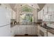 Clean bright kitchen with white cabinets, modern appliances, and a beautiful window at 10478 W 82Nd Ave, Arvada, CO 80005