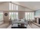 Inviting living room with a cozy fireplace, ample natural light from large windows, and comfortable seating at 10478 W 82Nd Ave, Arvada, CO 80005