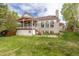 Spacious backyard with lush green grass, mature trees, and a covered deck offers great outdoor living at 20816 E Shefield Pl, Parker, CO 80138