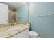 Bright bathroom featuring granite vanity top, white cabinets, brushed gold faucet and light blue walls at 20816 E Shefield Pl, Parker, CO 80138
