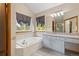 Bright bathroom with double vanity, granite countertops, soaking tub, and natural light at 20816 E Shefield Pl, Parker, CO 80138