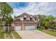 Two-story home with a three-car garage, tile roof, and manicured landscaping under a partly cloudy sky at 20816 E Shefield Pl, Parker, CO 80138