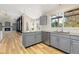 Bright kitchen featuring wood floors, grey cabinetry, granite countertops, stainless steel appliances, and a large window at 20816 E Shefield Pl, Parker, CO 80138
