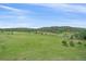Expansive green backyard with scattered trees and scenic views of the property at 26085 Amy Cir, Conifer, CO 80433