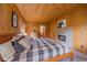 Bedroom features knotty pine walls, a fireplace, and access to the bathroom at 26085 Amy Cir, Conifer, CO 80433