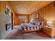 The knotty pine bedroom has a fireplace, an adjacent bath, and scenic views at 26085 Amy Cir, Conifer, CO 80433