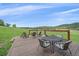 Spacious deck featuring comfortable seating and views of the property's green meadow at 26085 Amy Cir, Conifer, CO 80433