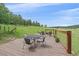 Wooden deck with seating and a fire pit overlooking the green meadow at 26085 Amy Cir, Conifer, CO 80433