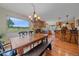 Dining room boasting a stone fireplace, a large window with a scenic view, and hardwood floors at 26085 Amy Cir, Conifer, CO 80433