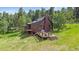 Charming home with multiple decks, nestled in a wooded area, surrounded by trees and greenery at 26085 Amy Cir, Conifer, CO 80433