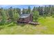 Charming home with multiple decks, nestled in a wooded area, surrounded by trees and greenery at 26085 Amy Cir, Conifer, CO 80433