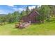 Charming home with multiple decks, nestled in a wooded area, surrounded by trees and greenery at 26085 Amy Cir, Conifer, CO 80433