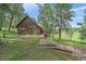 Charming wood-sided cabin with a unique window design and a wooden walkway leading to the entrance at 26085 Amy Cir, Conifer, CO 80433