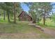 Secluded wood-sided cabin nestled amongst the trees, featuring a wooden walkway leading to the main entrance at 26085 Amy Cir, Conifer, CO 80433