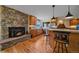 Charming kitchen with wood cabinets, granite countertops, a stone fireplace, and a breakfast bar at 26085 Amy Cir, Conifer, CO 80433
