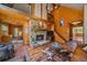 Open-concept living room features a stone fireplace, wooden accents, and a cozy atmosphere for gatherings at 26085 Amy Cir, Conifer, CO 80433