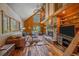 Bright and airy living room with large windows, stone fireplace, and wooden accents, creating a serene space at 26085 Amy Cir, Conifer, CO 80433