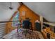 Third-floor home office with knotty pine walls, sloped ceilings, and large window at 26085 Amy Cir, Conifer, CO 80433